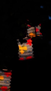 vertical video of vesak lanterns glowing at night during buddhist festival