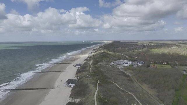 Luftbildvideo von Dishoek bei Zoutelande mit Strand, Meer und D&uuml;nen unter sonnigem Himmel mit Wolken, Zeeland, Niederlande