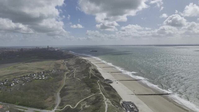 Luftbildvideo von Dishoek bei Zoutelande mit Strand, Meer und D&uuml;nen unter sonnigem Himmel mit Wolken, Zeeland, Niederlande