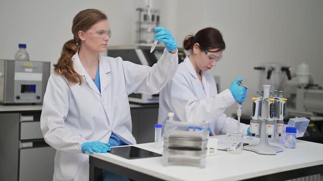 Scientists work in a lab conducting experiments with equipment and samples