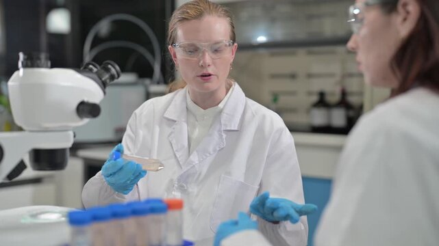 Scientists discuss research findings in laboratory setting with microscope and samples present