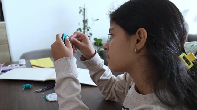 Happy Teenager Girl Learning To Sew With Needle And Thread At Home