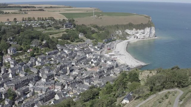 Aerial view of the coastal village of Yport featuring white chalk cliffs, a pebble beach and traditional rooftops along the Alabaster Coast in Yport, Normandy, France.