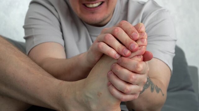 Bruised big toe.
A man screams in pain.
He touches his foot and massages it with his toe and toe.