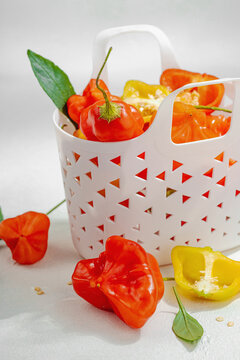 Culinary background of assorted fresh chili peppers in a white decorative basket. Raw ingredients