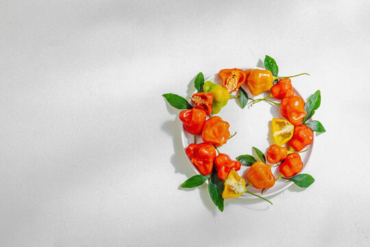 Culinary background of assorted fresh chili peppers on a ceramic plate. Vibrant ingredients