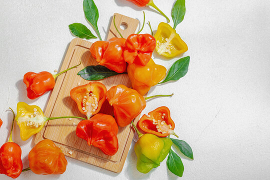 Culinary background of assorted fresh chili peppers arranged on a wooden cutting board