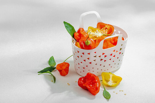 Culinary background of assorted fresh chili peppers in a white decorative basket. Raw ingredients