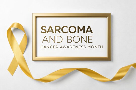 Yellow ribbon lies next to a gold frame containing text about sarcoma and bone cancer awareness month.