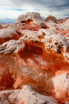 View of the unique swirling sandstone and white brain rock formations at White Pocket under a cloudy sky in Coconino County, Arizona, United States.
