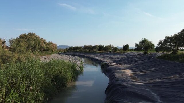 Aerial view of the rio Segura riverbed restoration project utilizing black plastic covers on the banks to eradicate invasive giant reeds thus protecting the agricultural landscape ecology in Murcia 