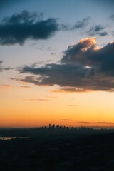 Fototapeta premium Sunset over city skyline with cloudy sky