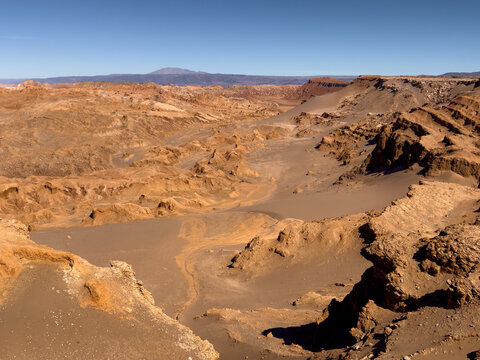 View of the rugged rock formations and vast sand dunes of Mars Valley under a clear blue sky in the Atacama Desert San Pedro de Atacama, Antofagasta, Chile.