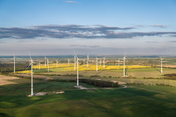 Aerial view of a large wind farm spread across agricultural land in Germany. Modern wind turbines produce renewable electricity while coexisting with farmland and rural communities.  © Daniel