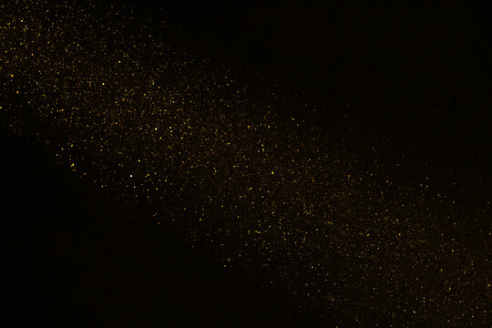 Stardust. falling shower rain corpuscular particle snow flying fallen Freeze shot on black background isolated overlay Spray water yellow golden gold dust explosion abstract powder splattered