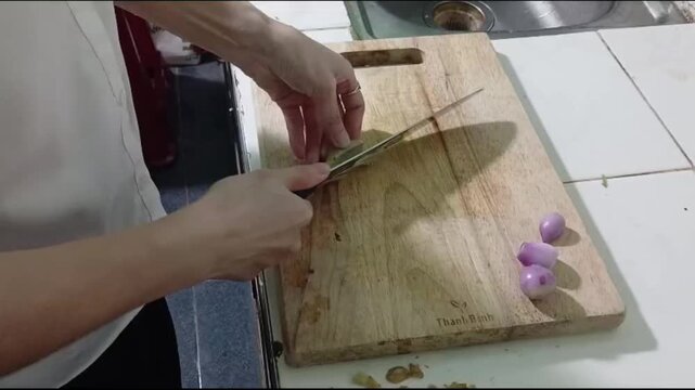 Hands Cutting Fresh Ginger into Thin Slices for Cooking