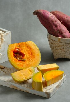 Chopped butternut squash pieces (Cucurbita moschata), also known as butternut pumpkin or labu madu, cut  on a gray background.