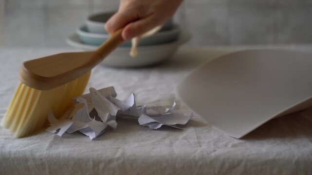 Video of cleaning crumbs and small debris from a table surface as part of an eco-friendly housekeeping routine