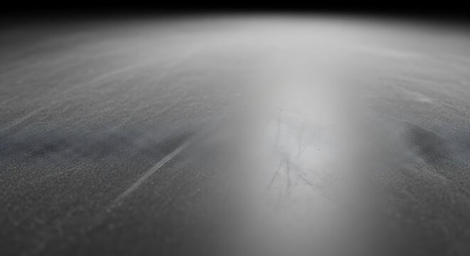 Abstract empty black chalk baord texture background with dust and scratches under bright dramatic spotlight spotlighting with shallow depth of field.