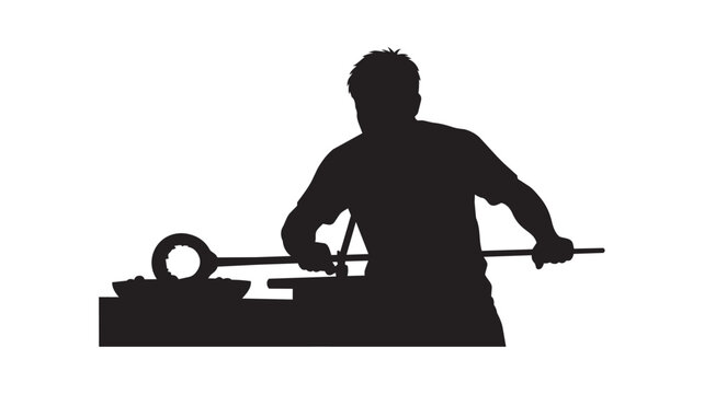 Silhouette of a glassblower working with molten glass