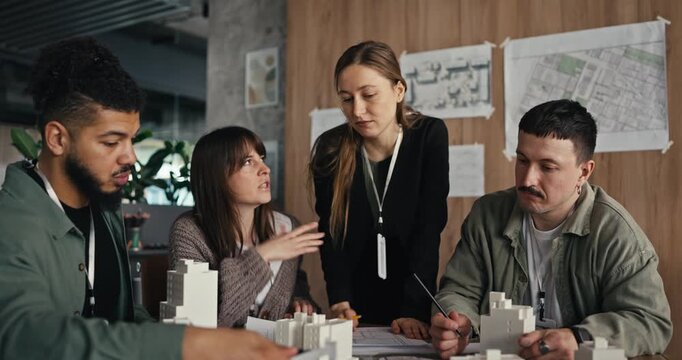 Group of people share thoughts and build models while working on a project plan in the office space