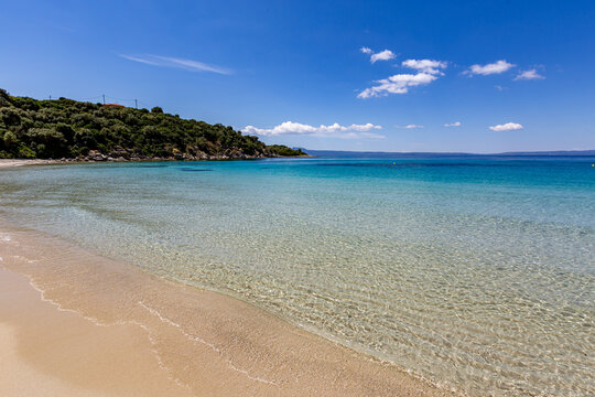 Beach with a boat in the water and a hill in the background, Ammoulliani, Greece