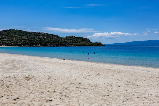 There are people on the beach in the water and in the sand, Ammoulliani, Greece