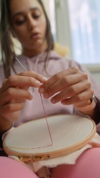 Focus on even tension during delicate embroidery project indoors