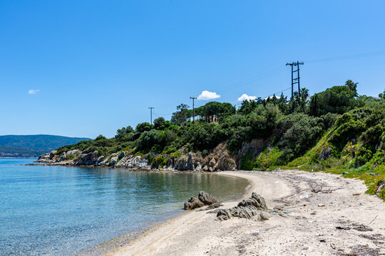 Beach with a boat on the water and a hill in the background, Ammoulliani, Greece