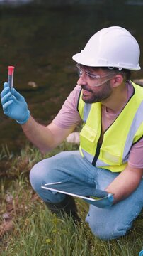 vertical Environmental engineer analyzing a water sample for pollution