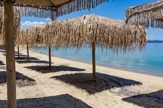 There are many straw umbrellas on the beach near the water, Ammoulliani, Greece