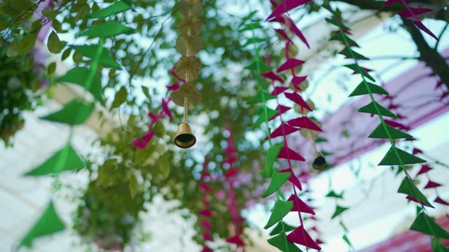 Cinematic Panning Shot of Hanging Traditional Bells and Decorative Floral Garlands