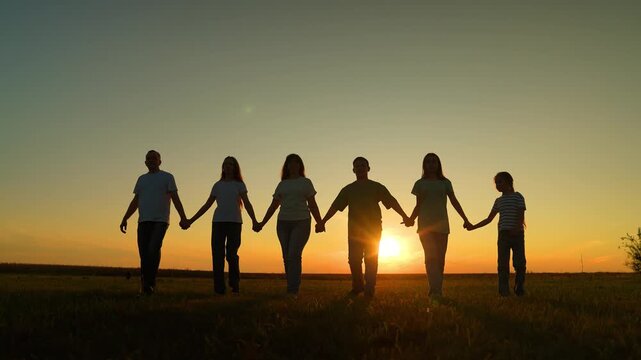 community unity: people hand in hand at dusk, this outdoor moment captures childhood joy and strong parental care., sunset bond: people lined up holding hands in peace, united family silhouettes