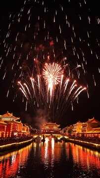Magnifique feu d'artifice rouge au-dessus d'une ville traditionnelle chinoise et d'un fleuve