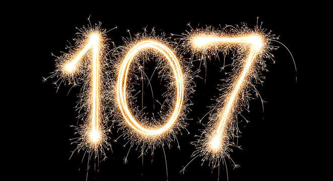 Vibrant sparklers forming the number 107 against a dark backdrop, creating a celebratory and dynamic visual effect.