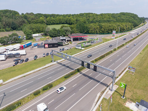 30 May 2026, Rotselaar, Belgium. Aerial drone view of E314 highway with traffic monitoring gantry and adjacent service station infrastructure