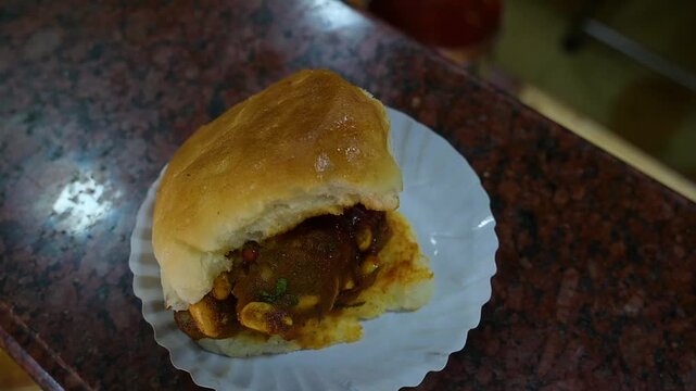 Dabeli a spicy-sweet Gujarati street snack made with masala potato stuffed in pav and topped with chutneys and sev
