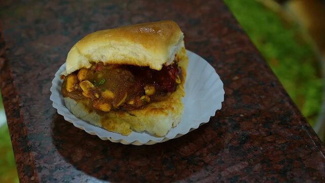 Dabeli a spicy-sweet Gujarati street snack made with masala potato stuffed in pav and topped with chutneys and sev
