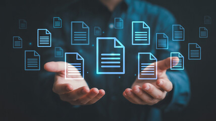 Naklejka premium Man holding glowing document icons representing cloud data storage and electronic paperless archive system.