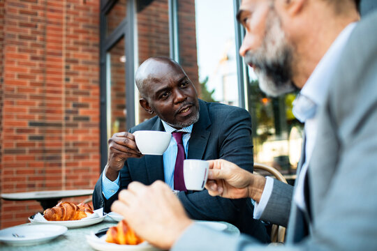 Two business colleagues having coffee at outdoor cafe