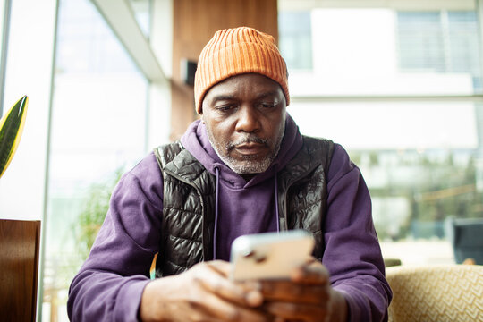 Mature man using smartphone in cafe