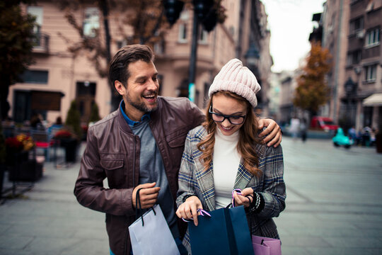 Happy couple shopping on city street in autumn