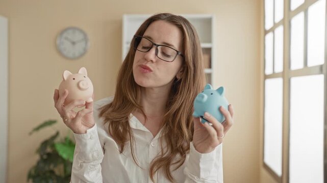 Woman comparing pink and blue piggy banks, holding both and inspecting slots, bare hands visible in building; savings choice thoughtful.