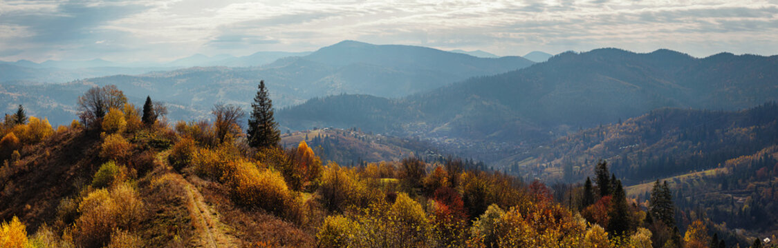 Early morning sun shining on a fall hiking route amidst the tree covered Carpathian Mountains of Lviv region, Slavsko, Ukraine.