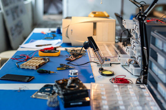Electronics repair bench with tools, circuit boards, and test equipment