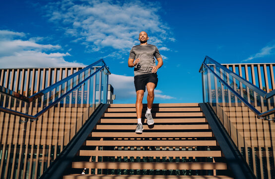 Handsome sportive man in athletic wear doing workout exercise, athlete enjoying an outdoor run session in city, fitness motivation and urban wellness