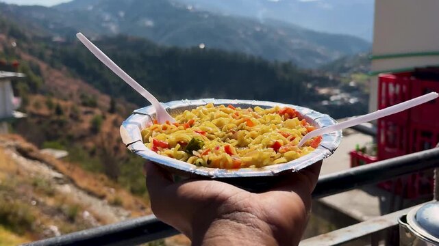 hot vegetable maggi noodles served with scenic mountain valley view in himalayas
