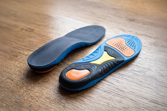 Ergonomic running insoles with shock absorption on wooden background