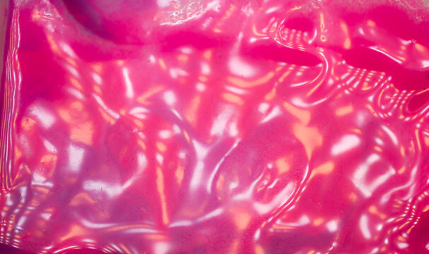 Vivid pink magenta glossy texture full frame macro with light reflections and wet surface abstract background for creative design. 