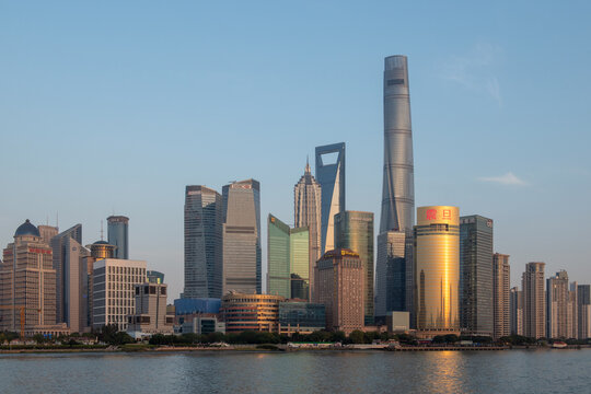View of the modern Pudong skyline featuring the Shanghai Tower and Jin Mao Tower across the Huangpu River under a clear sky in Shanghai, Shanghai, China.